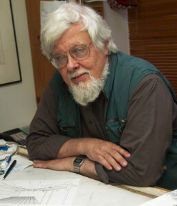 Headshot of James Wines who wears a green vest and brown shirt.