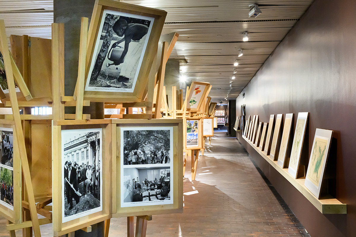 A view inside Druker Design Gallery showing wooden structures with display panels built around the columns and a shelf with display panels along the wall.