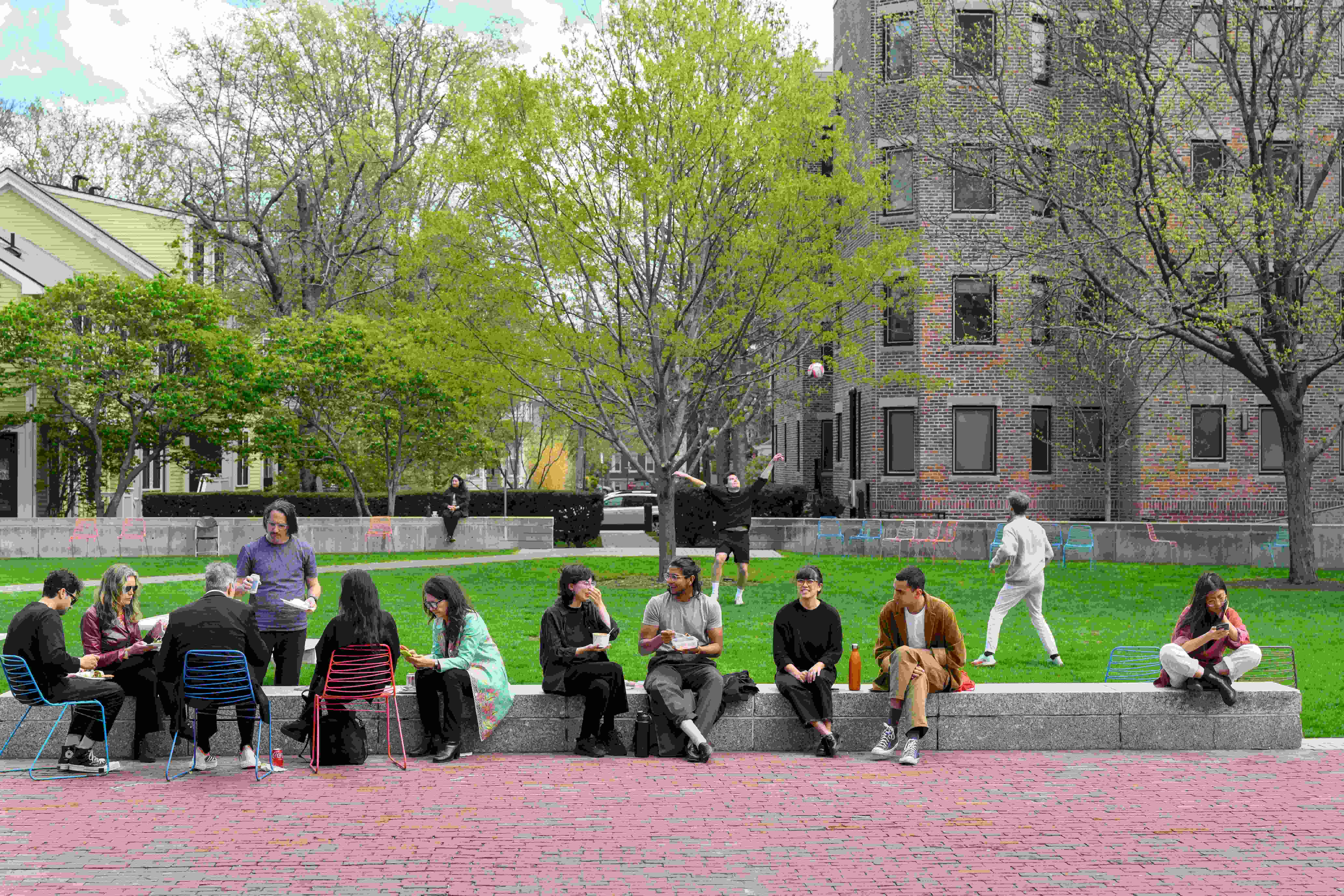 Students, faculty, and visitors gather in Gund Hall's courtyard.