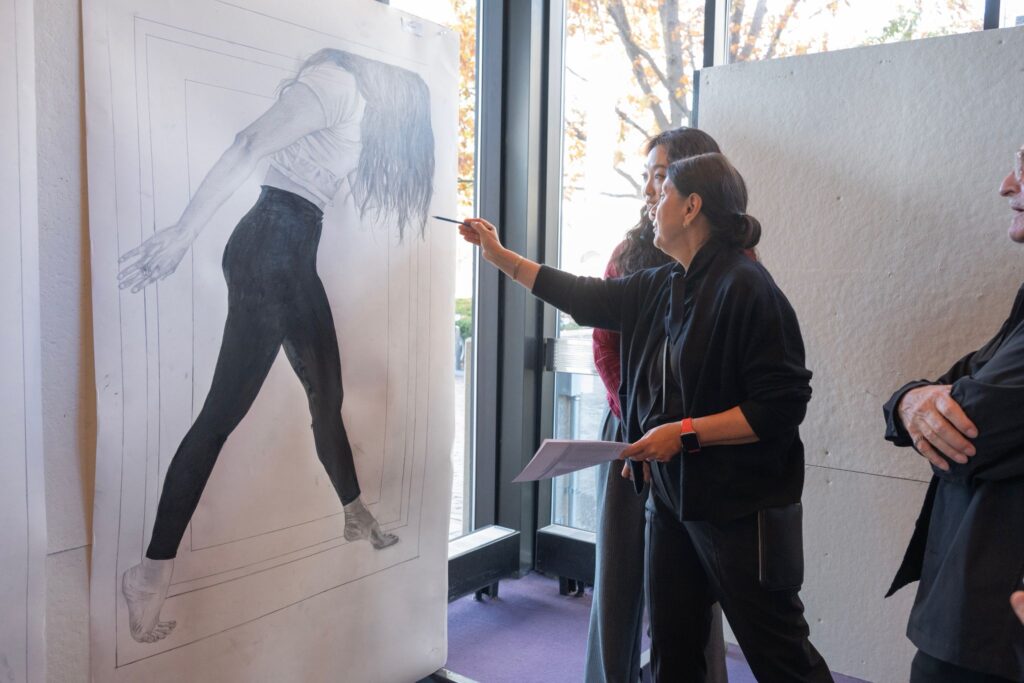 Instructor points to drawing beside student